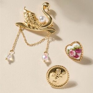Francesca's Collections Gold Colored Swan, Cupid, and Floral Brooch Trio